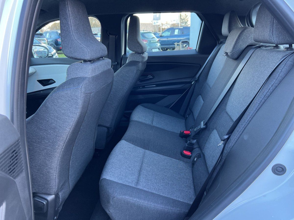 Rücksitzbank mit grauem Stoffbezug und Sicherheitsgurten im Fahrzeuginnenraum beim Händler