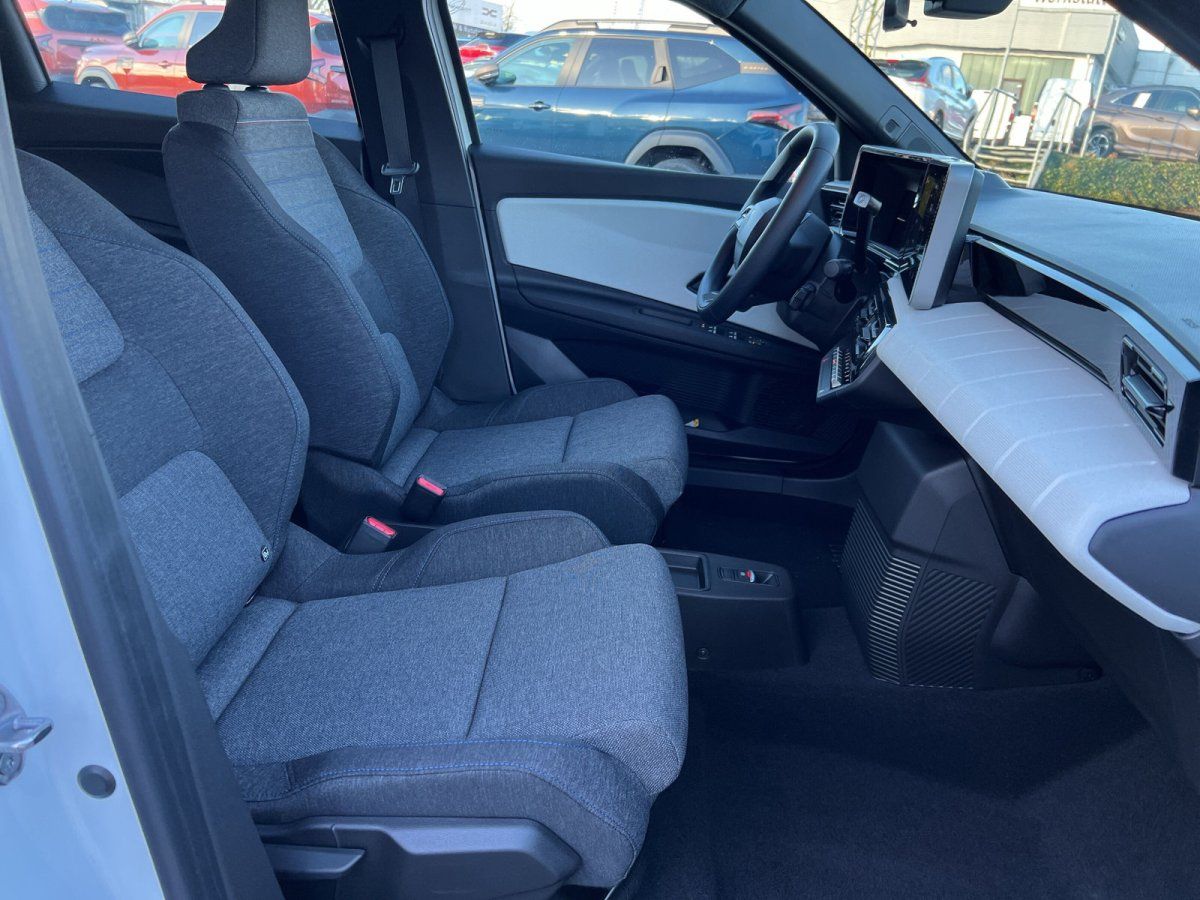 Innenraum VW ID. Buzz mit grauen Stoffsitzen und Touchscreen-Display im Showroom