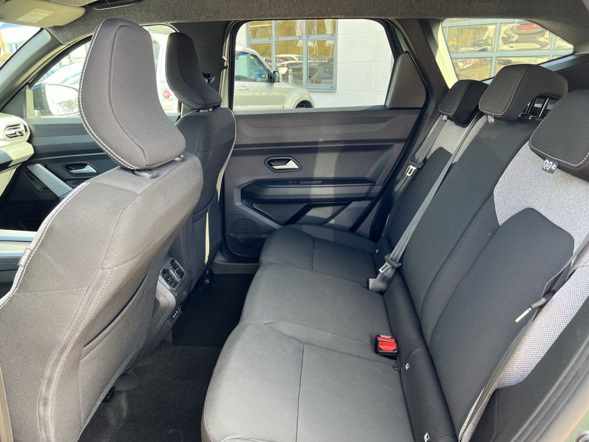 Rücksitzbank eines Fahrzeugs mit grauen Sitzen und Blick nach vorne zum Cockpit