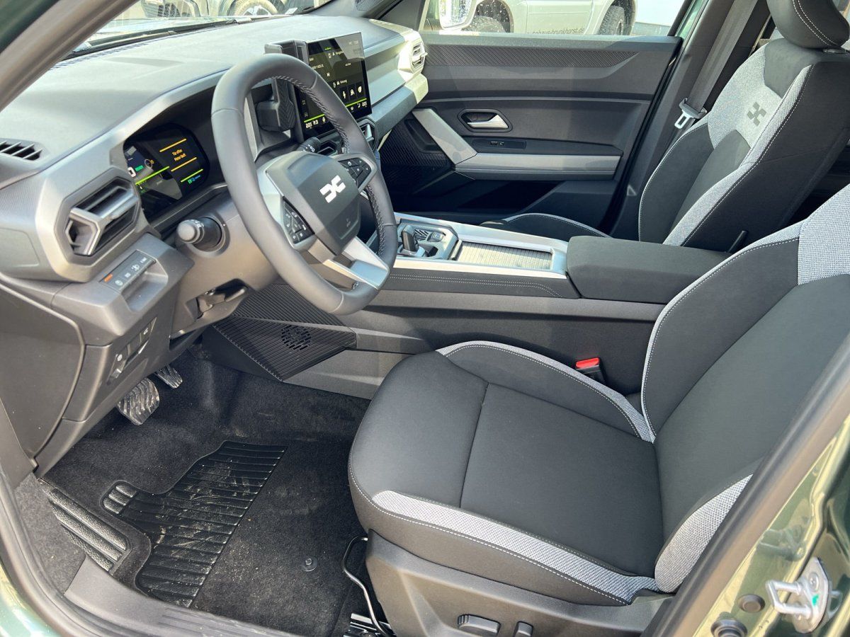 Dacia Innenraum mit modernem Cockpit - Lenkrad, Digitalanzeigen und graue Sportsitze