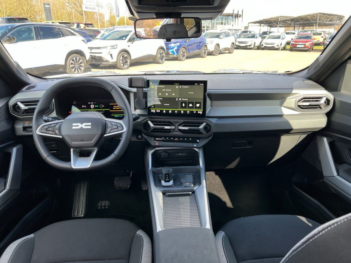 Innenraum eines Fahrzeugs mit modernem Cockpit, Touchscreen und Blick auf Autohaus-Showroom
