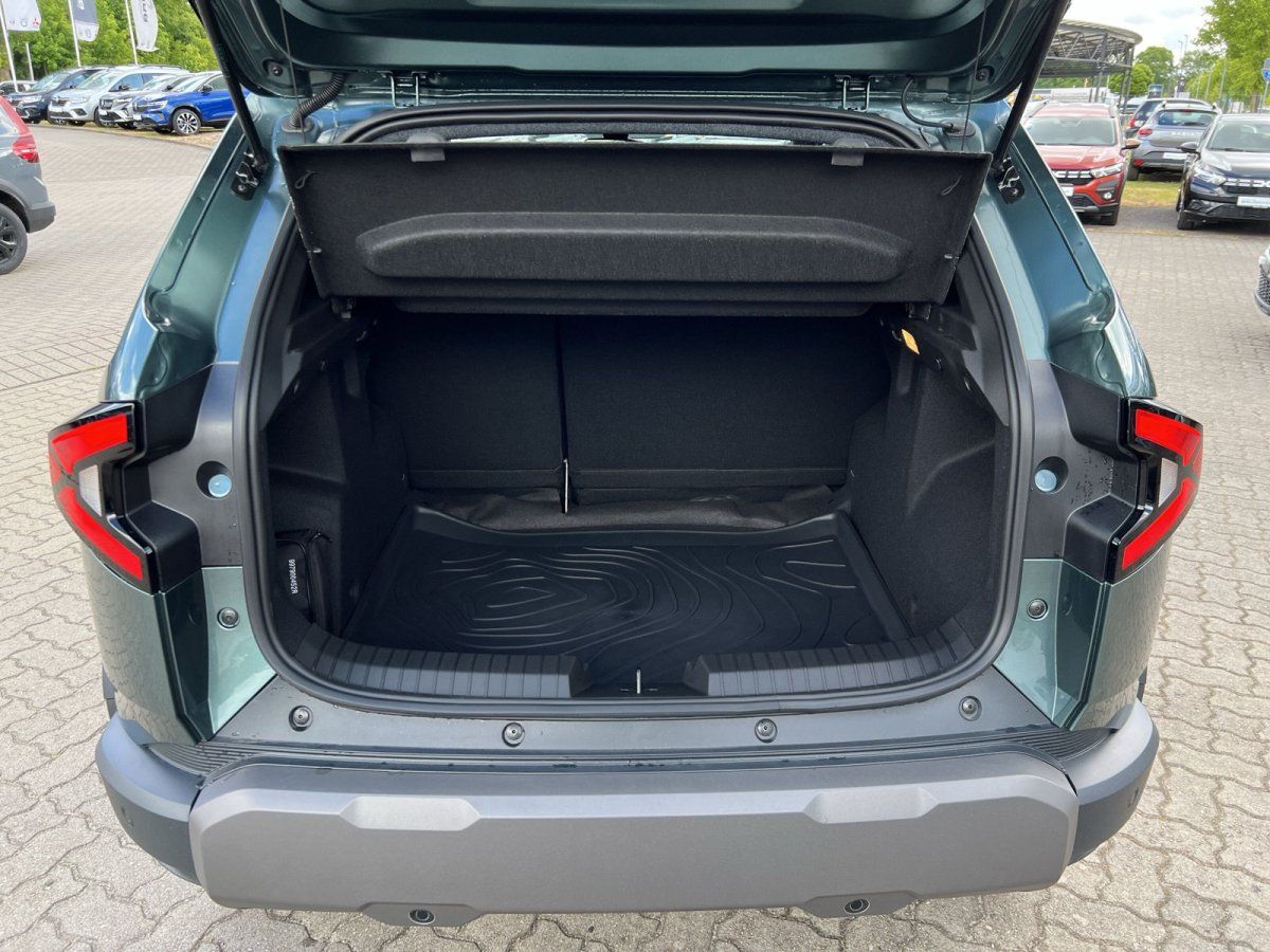 Grüner SUV Kofferraum geöffnet im Autohaus – geräumiger Laderaum mit schwarzem Teppich