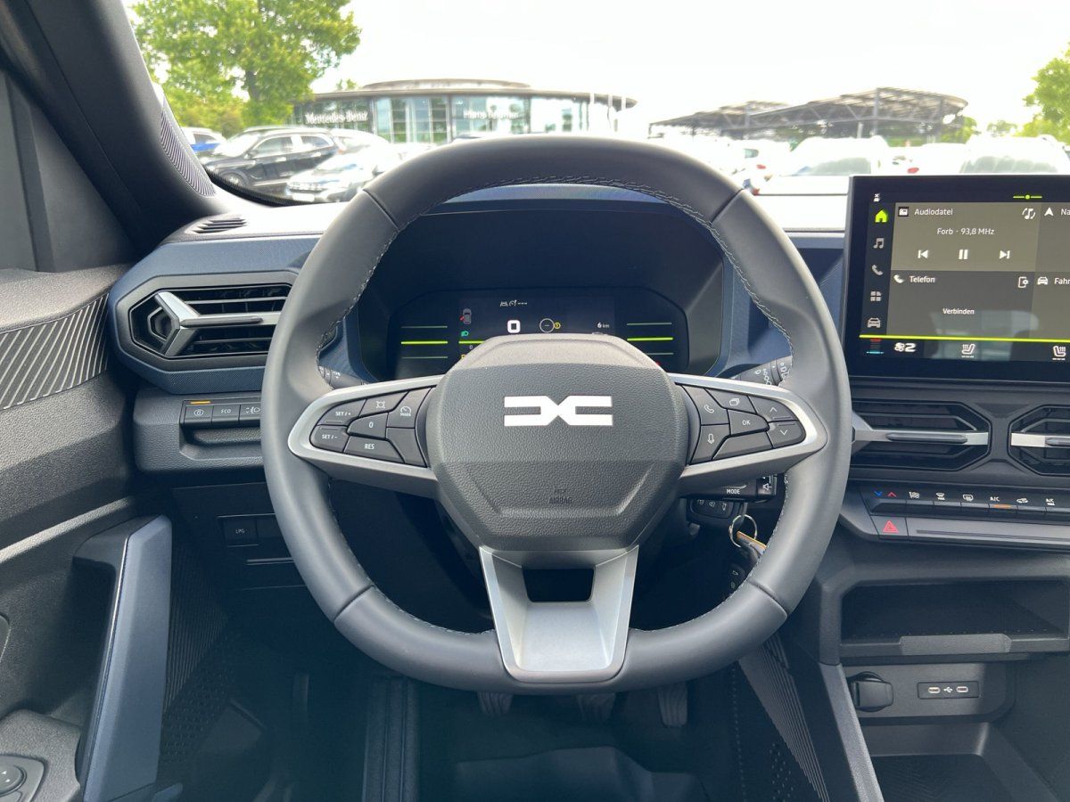 Dacia Innenraum mit Lenkrad, digitalem Cockpit und Infotainment-Bildschirm im Autohaus