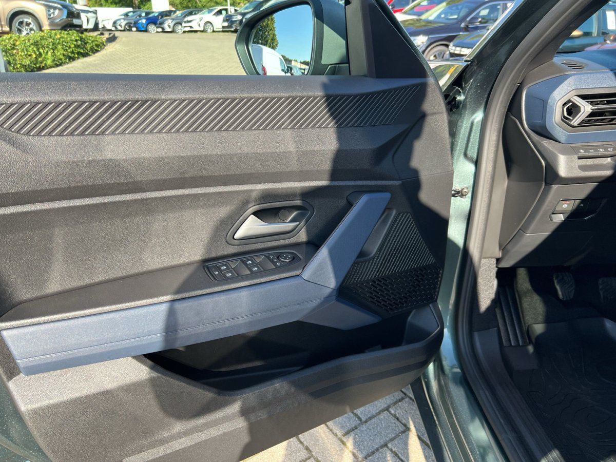 Fahrzeugtür Innenansicht mit Fensterheberschaltern und Lautsprecher, grünes SUV im Autohaus