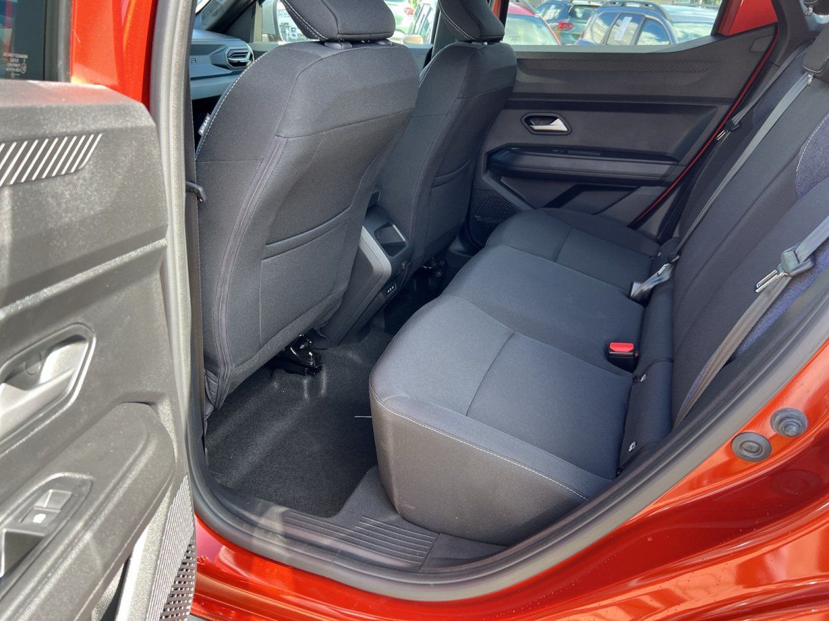 Rücksitzbank und Innenraum eines roten Kompakt-SUV mit schwarzen Stoffsitzen und Sicherheitsgurten