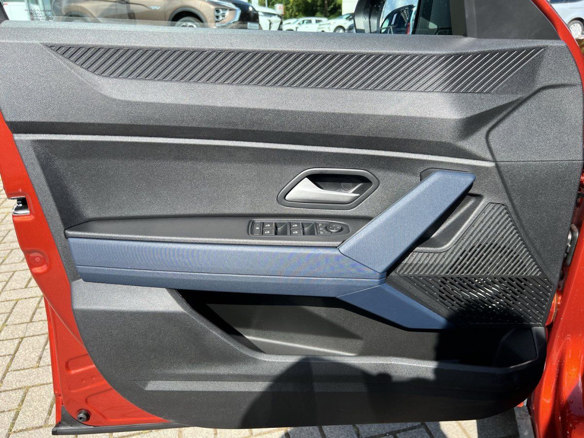 Türverkleidung Fahrerseite mit elektrischen Fensterhebern und blauem Armauflage-Akzent, rotes Fahrzeug