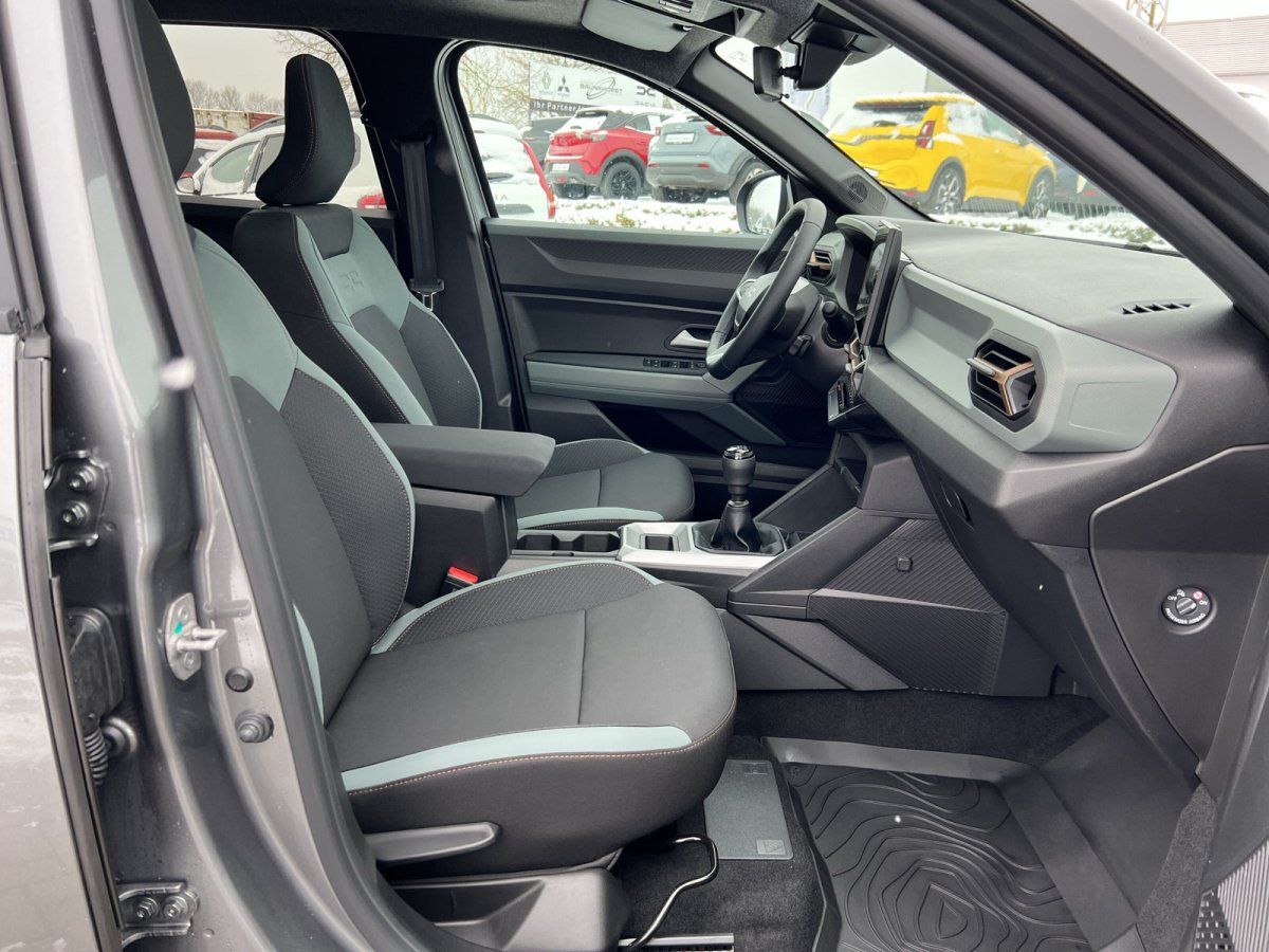 Fahrzeuginnenraum mit schwarzen Sportsitzen und mintfarbenen Akzenten, Schaltgetriebe und modernes Cockpit