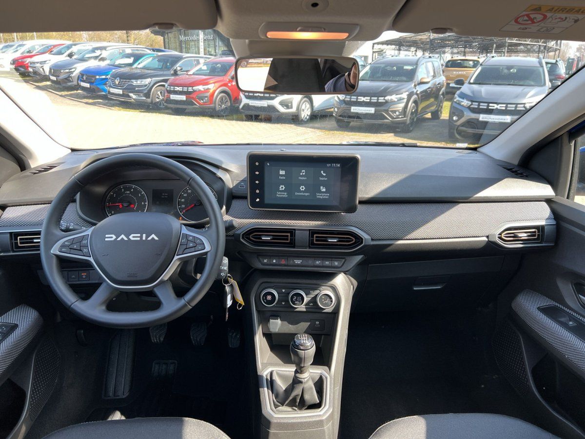 Dacia Innenraum mit Lenkrad, Touchscreen und modernem Armaturenbrett in grau