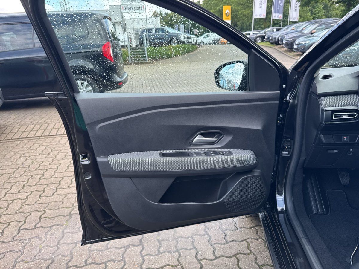 Schwarzes Fahrzeug Innenraum – geöffnete Fahrertür mit Türverkleidung und Armaturenbrett