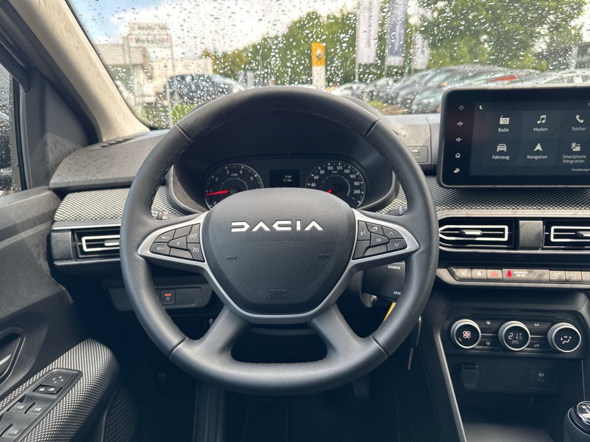 Dacia Innenraum mit Lenkrad, Kombiinstrument und Touchscreen-Infotainmentsystem im Autohaus