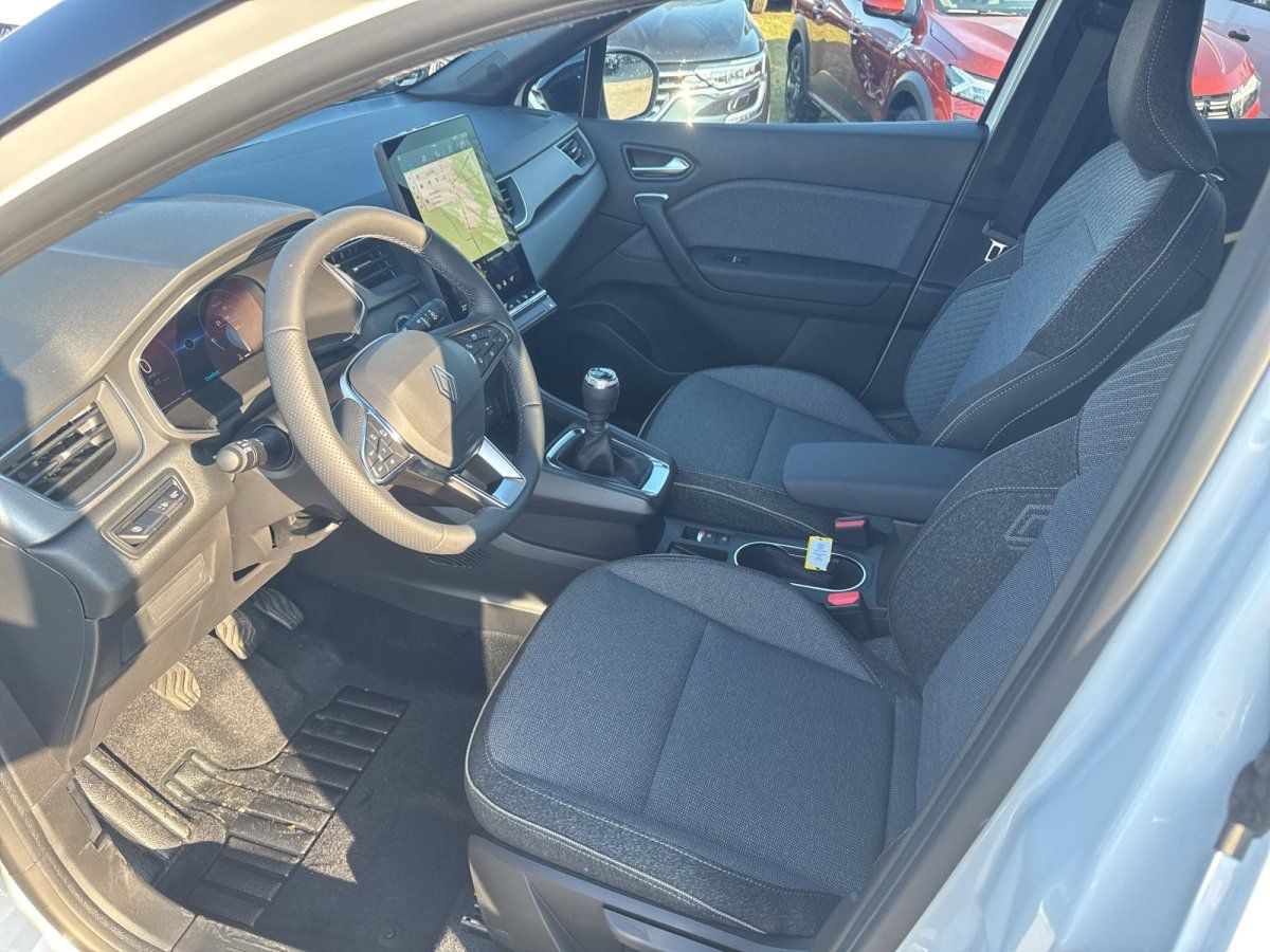 Renault Innenraum mit Lederlenkrad, großem Touchscreen und schwarzen Stoffsitzen in Showroom