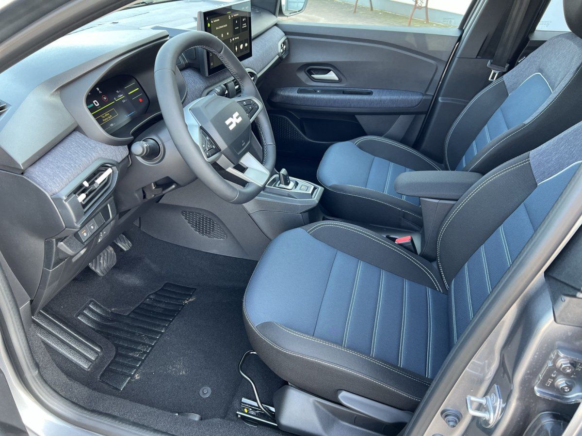 Dacia Innenraum Fahrersitz mit blau-schwarzen Stofssitzen und modernem Cockpit