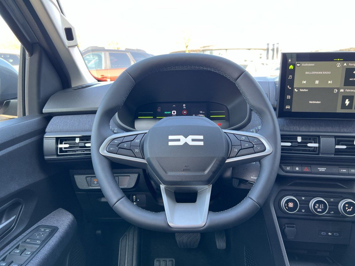 Dacia Innenraum mit Lenkrad, digitalem Cockpit und Infotainment-Touchscreen im Autohaus