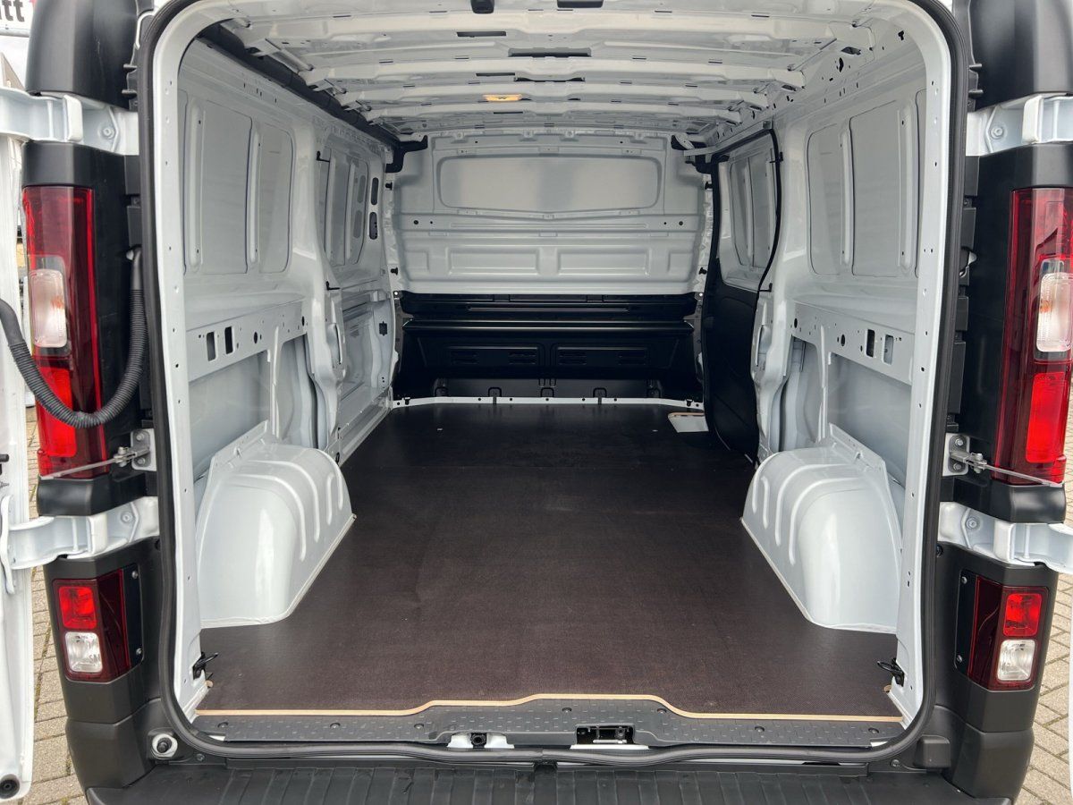 Laderaumansicht weißer Transporter mit geöffneten Hecktüren in Autohaus-Showroom