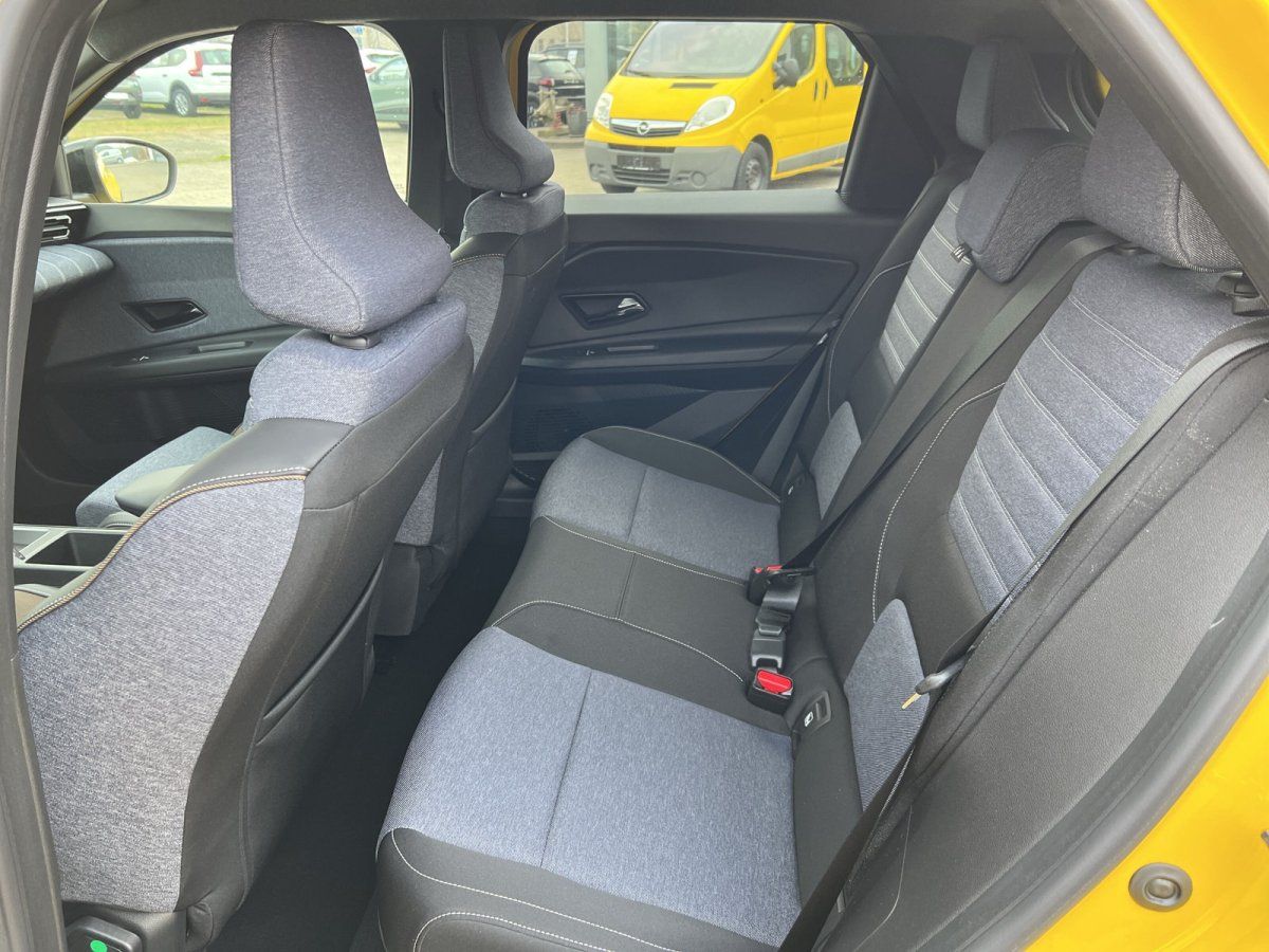 Innenraum Rücksitzbank eines gelben Fahrzeugs mit grau-schwarzen Stoffsitzen und Sicherheitsgurten