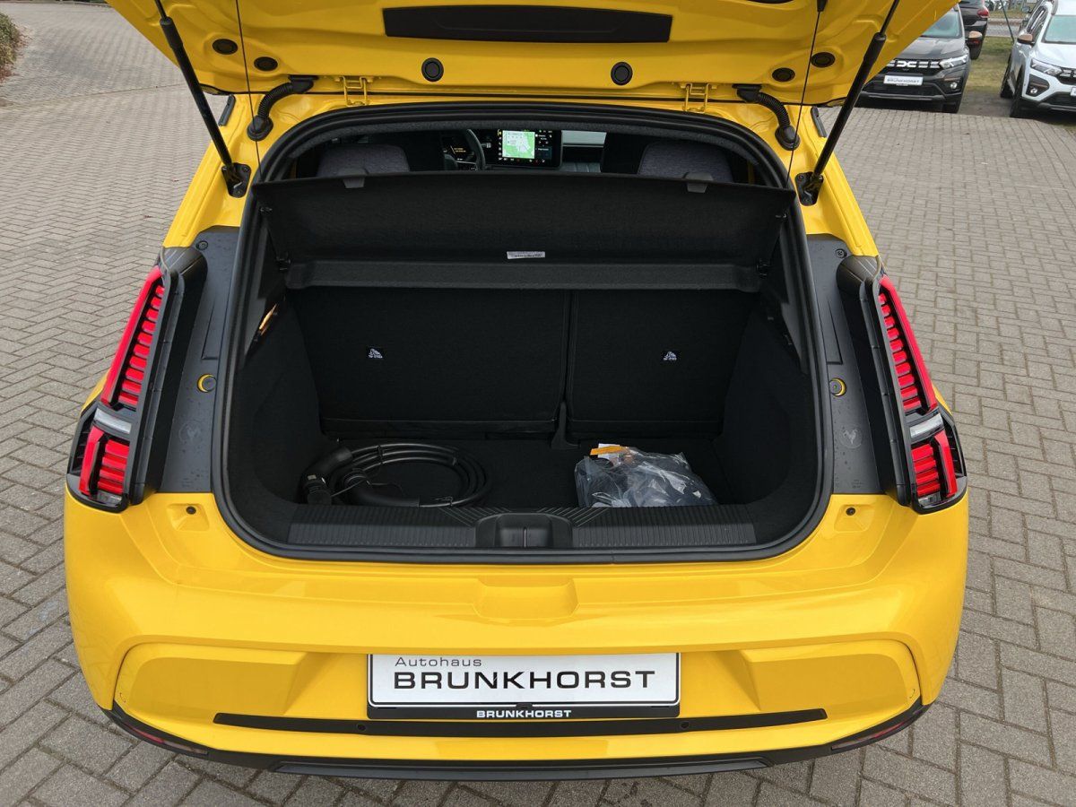 Gelber Kia EV3 mit geöffnetem Kofferraum im Autohaus Brunkhorst Showroom