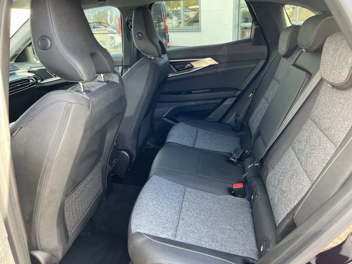 Rücksitzbank mit grauen Stoffsitzen und Blick durch Panoramafenster ins Autohaus