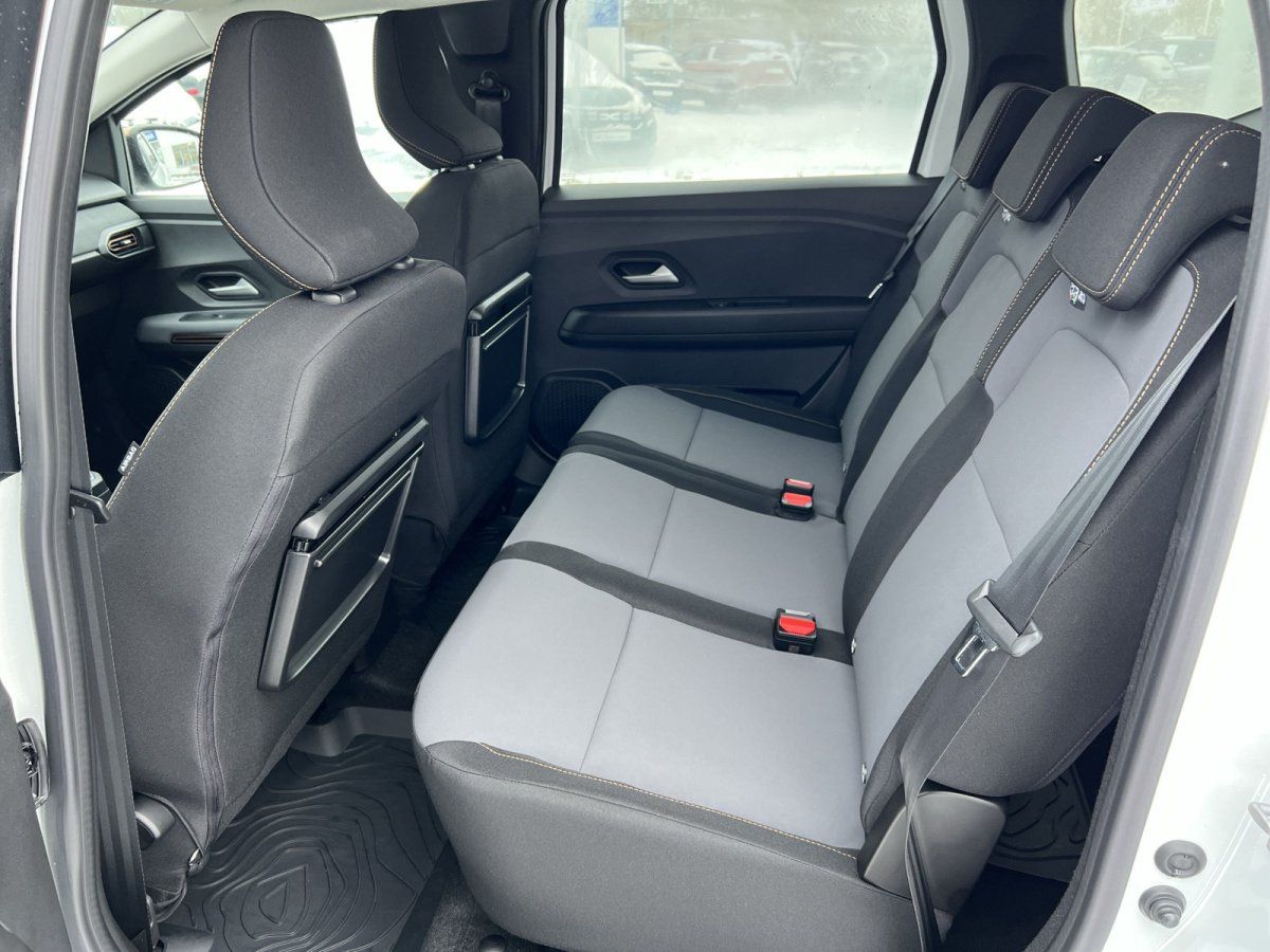 Rücksitzbank mit grau-schwarzen Stoffsitzen und Sicherheitsgurten im Fahrzeuginnenraum