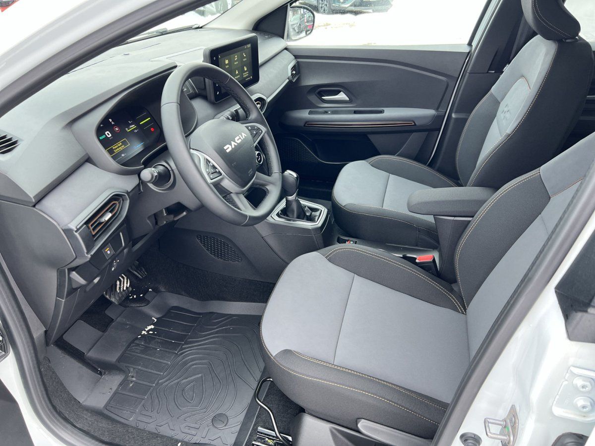 Dacia Innenraum mit digitalem Cockpit, Touchscreen und grau-schwarzen Sitzen mit Kontrastnähten