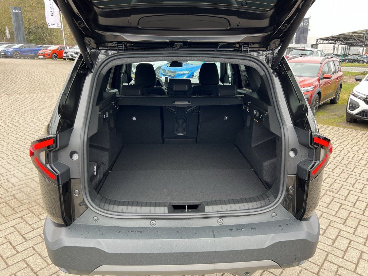 Geöffneter Kofferraum eines schwarzen SUV in Autohaus mit flach gelegten Rücksitzen