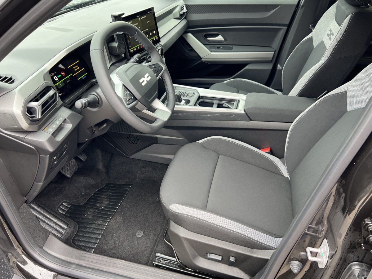 Dacia Innenraum mit Fahrersitz, Lenkrad und digitalem Cockpit in modernem SUV