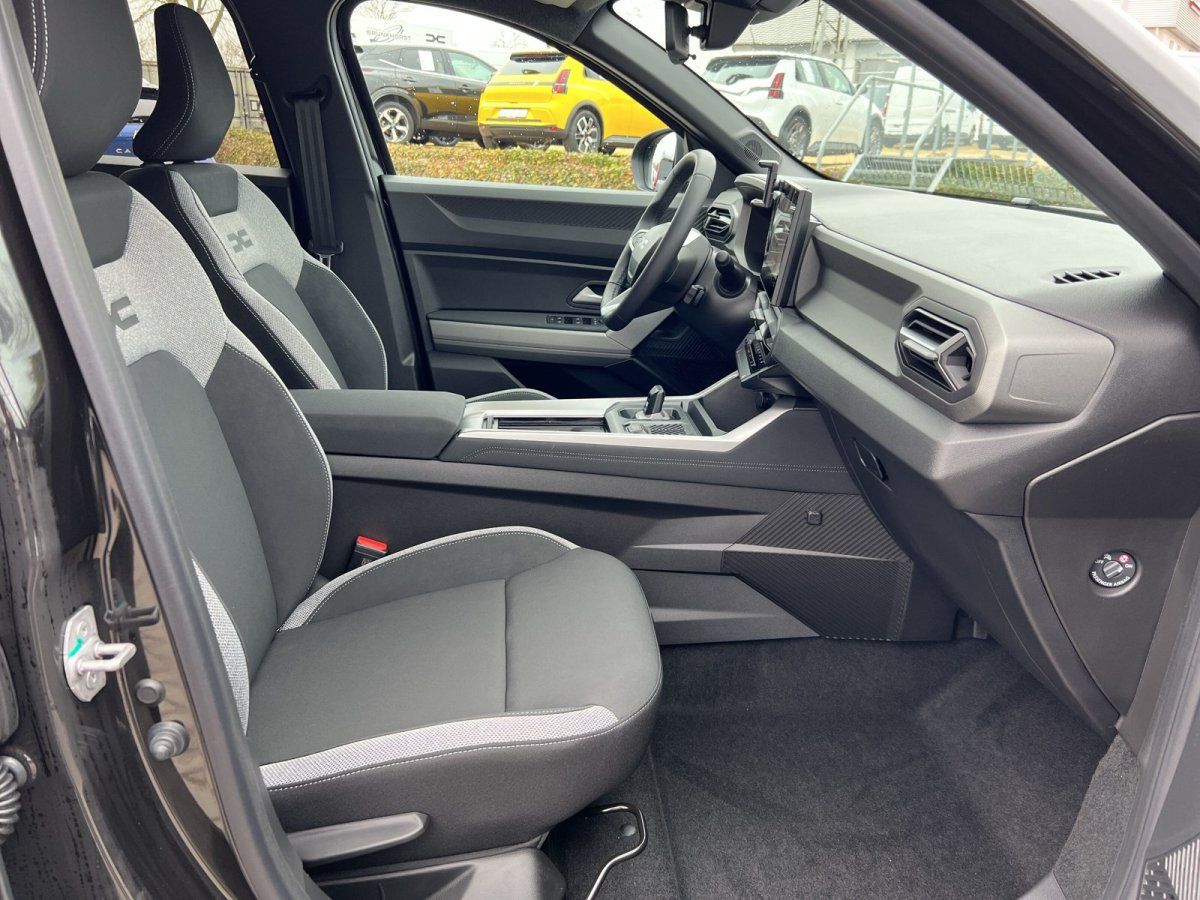 Fahrzeug Innenraum mit grauen Stoffsitzen, Mittelkonsole und Armaturenbrett in modernem SUV