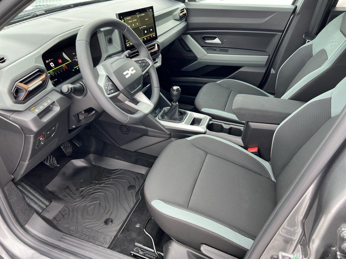 Dacia Innenraum mit Cockpit, Ledersitzen und Schaltgetriebe in modernem Showroom