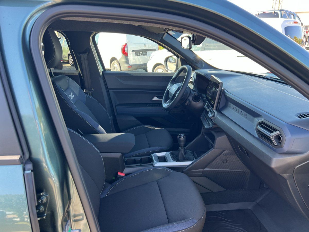 Dacia Duster Innenraum mit schwarzen Stofssitzen, Schaltgetriebe und digitalem Infotainment-Display