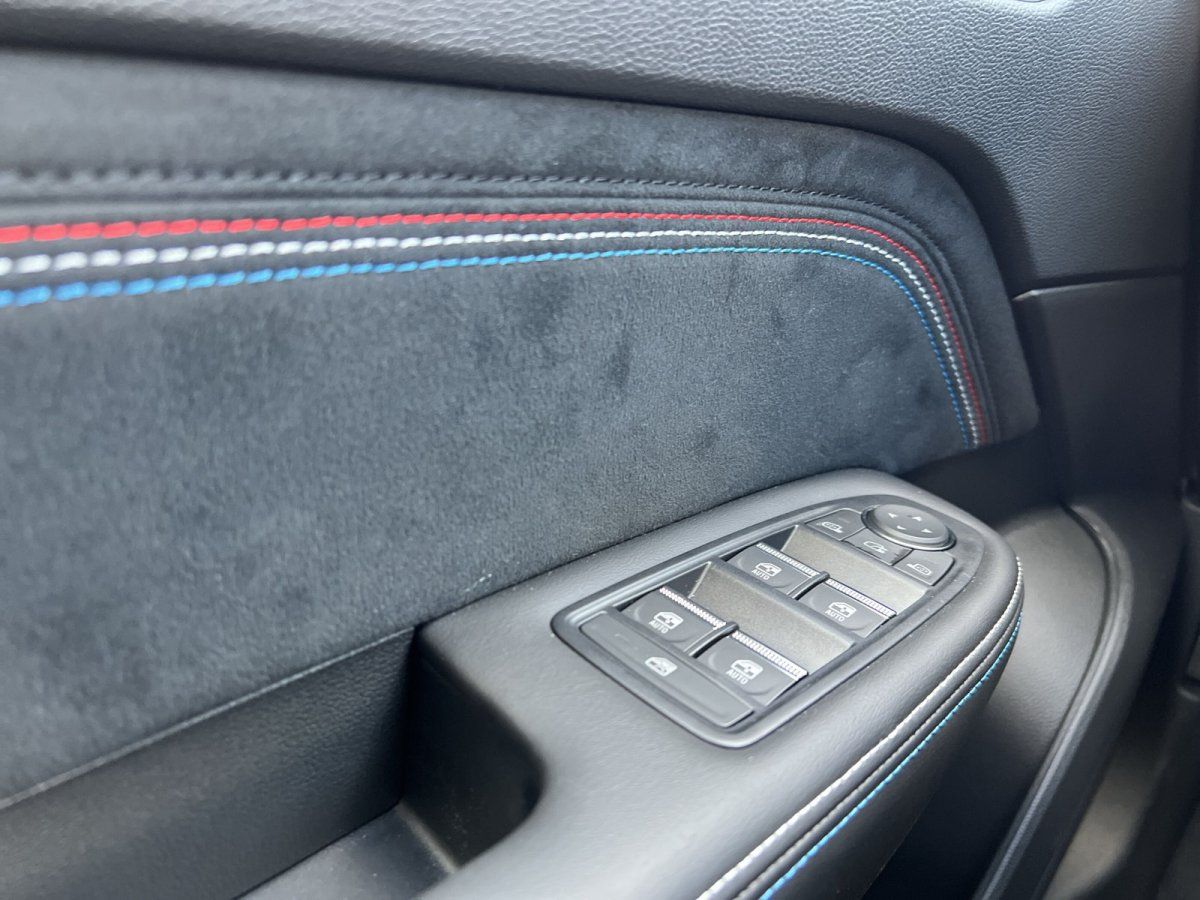 Fahrzeuginnenraum Fahrertür mit Alcantara-Verkleidung und dreifarbiger Ziernaht im Autohaus