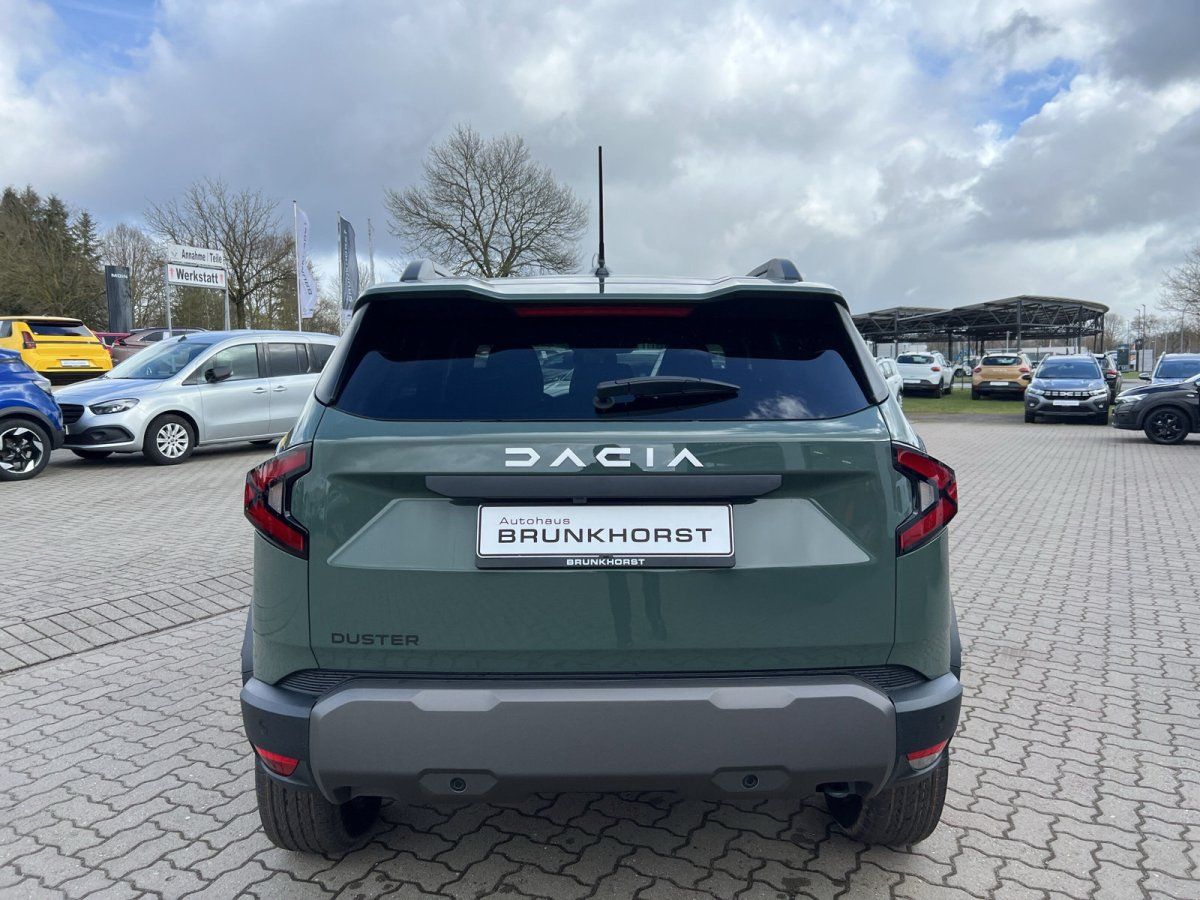 Dacia Duster Heckansicht in grün - SUV von hinten im Autohaus mit DACIA Schriftzug und Kennzeichen