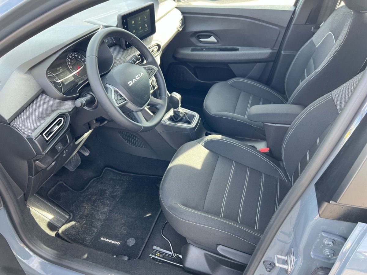 Dacia Sandero Innenraum mit schwarzen Stofssitzen, Lederlenkrad und Touchscreen-Infotainment