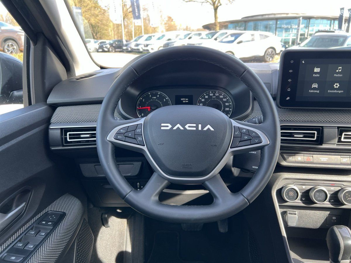 Dacia Innenraum mit Lenkrad, Armaturenbrett und Infotainment-Display im Autohaus