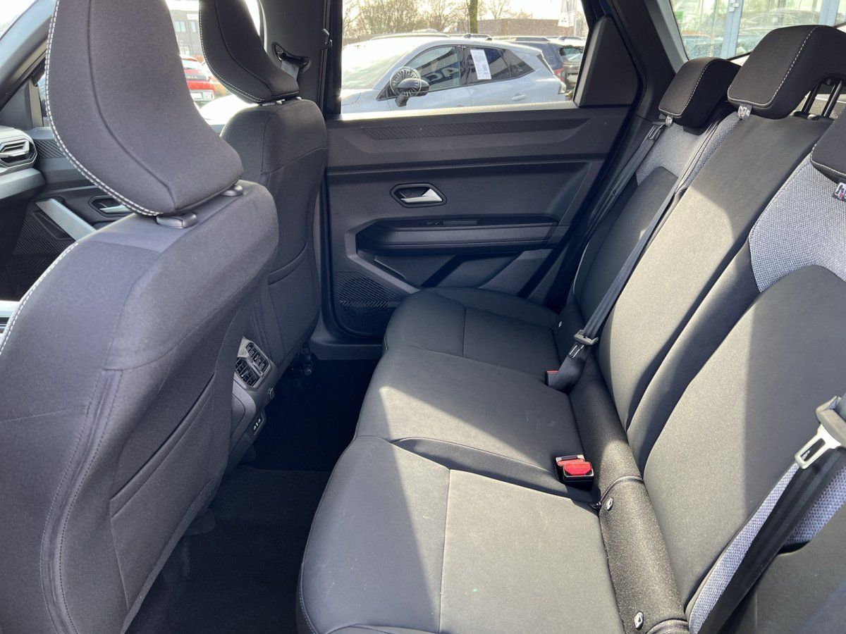 Dacia Rücksitzbank mit grauen Sitzen, Sicherheitsgurten und Blick durch Heckscheibe in Showroom