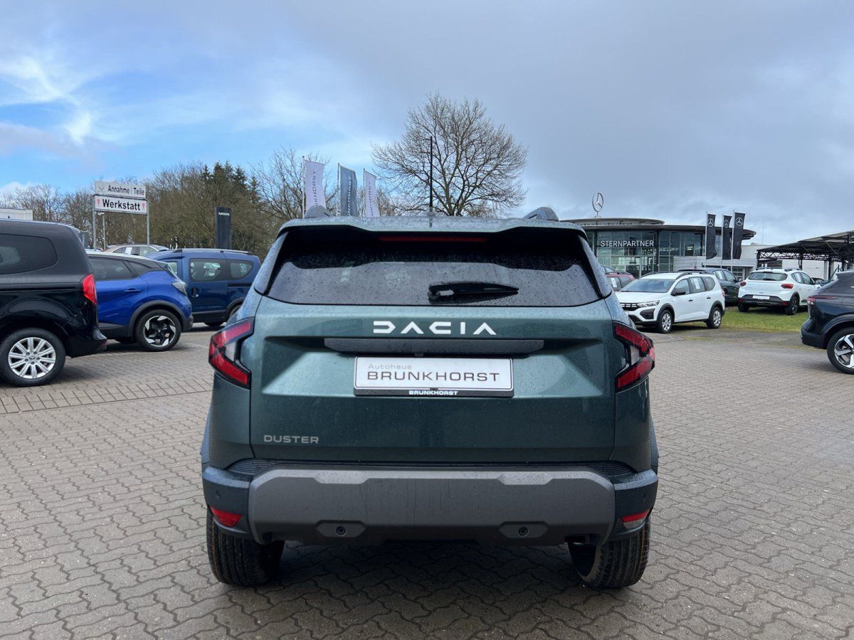 Dacia Duster Heckansicht in graugrün mit BRUNKHOSRT Kennzeichen im Autohaus-Showroom