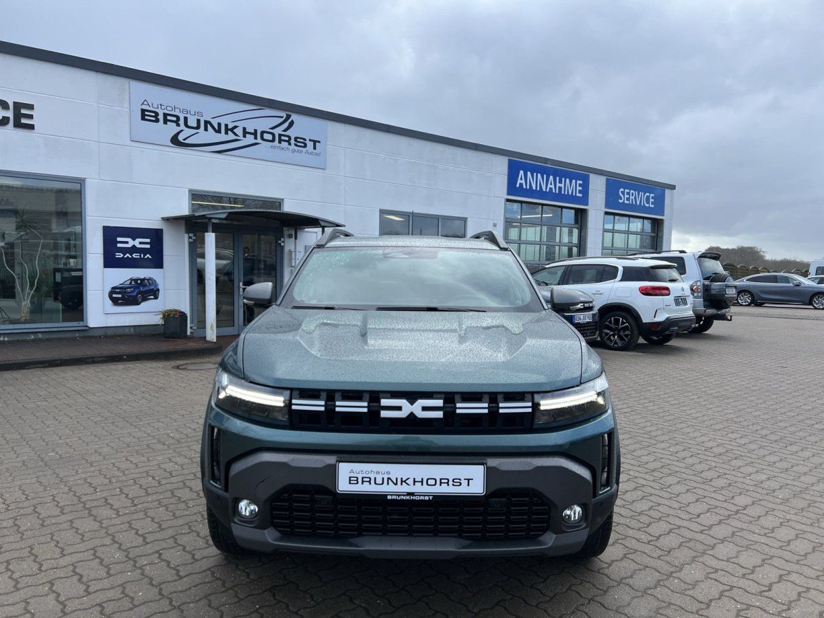 Dacia SUV Frontansicht graugrün mit BRUNKHOSRT Kennzeichen im modernen Autohaus
