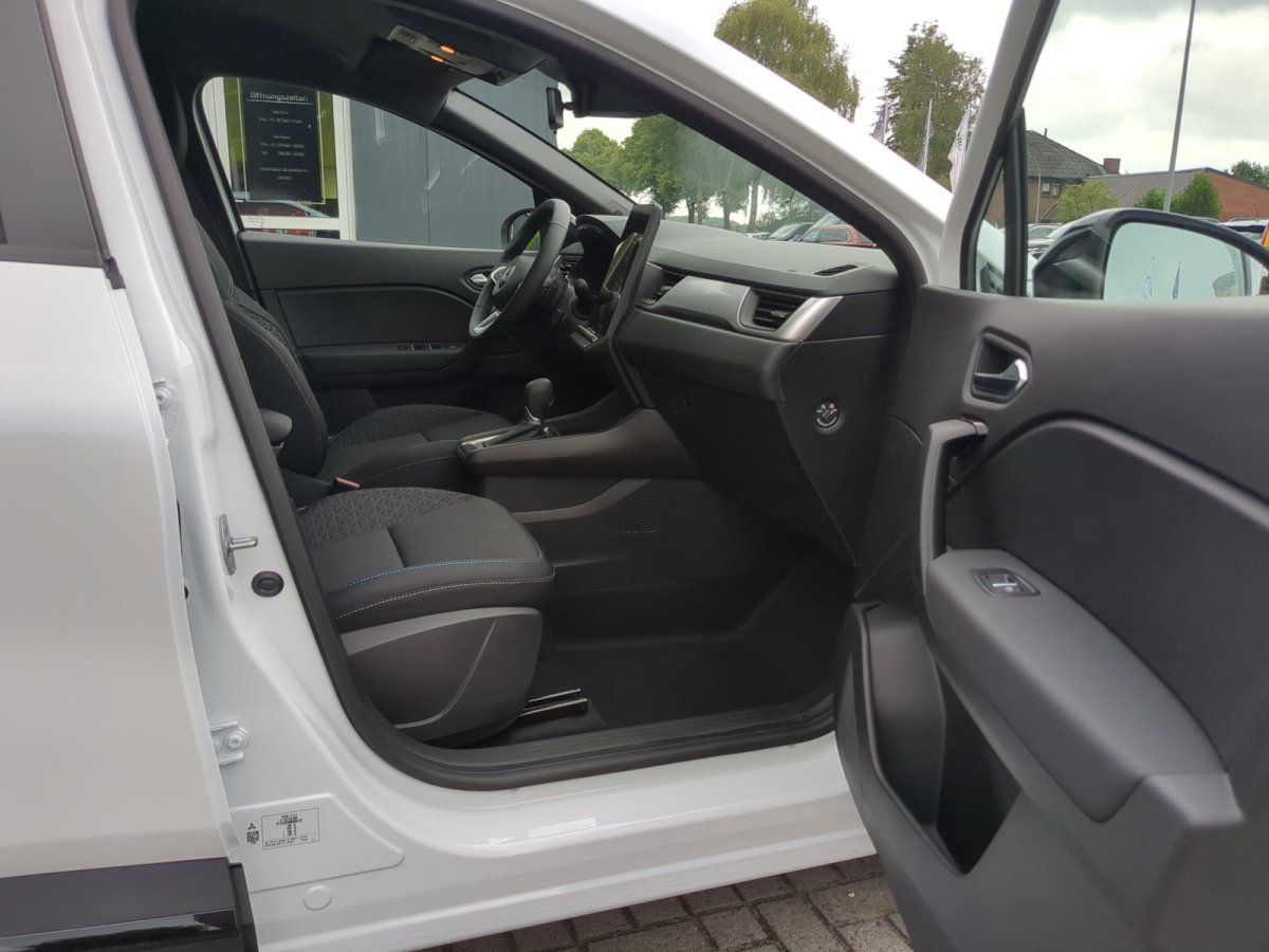 Innenraum eines weißen Fahrzeugs mit schwarzen Sportsitzen und modernem Cockpit im Autohaus