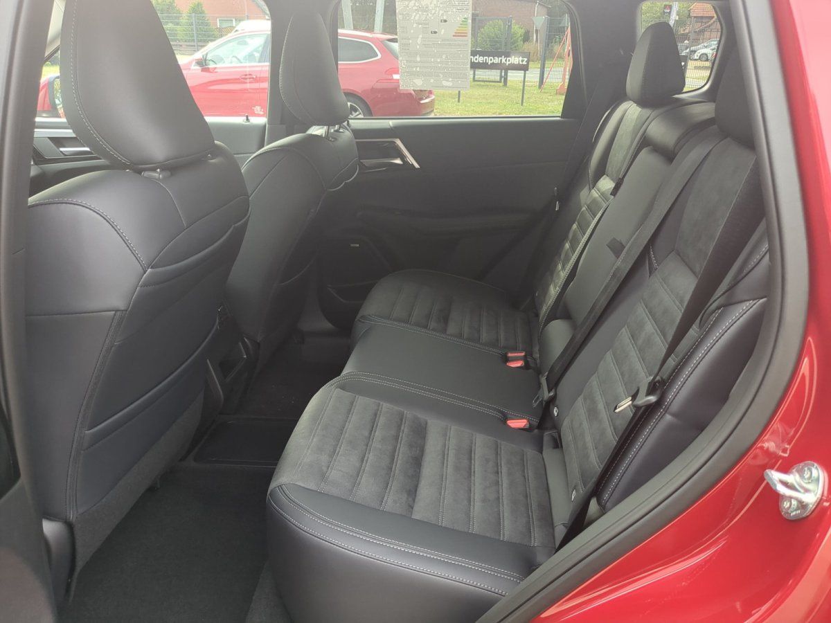 Rücksitzbank mit Leder-Alcantara-Polsterung in schwarzem Interieur eines roten SUV im Autohaus