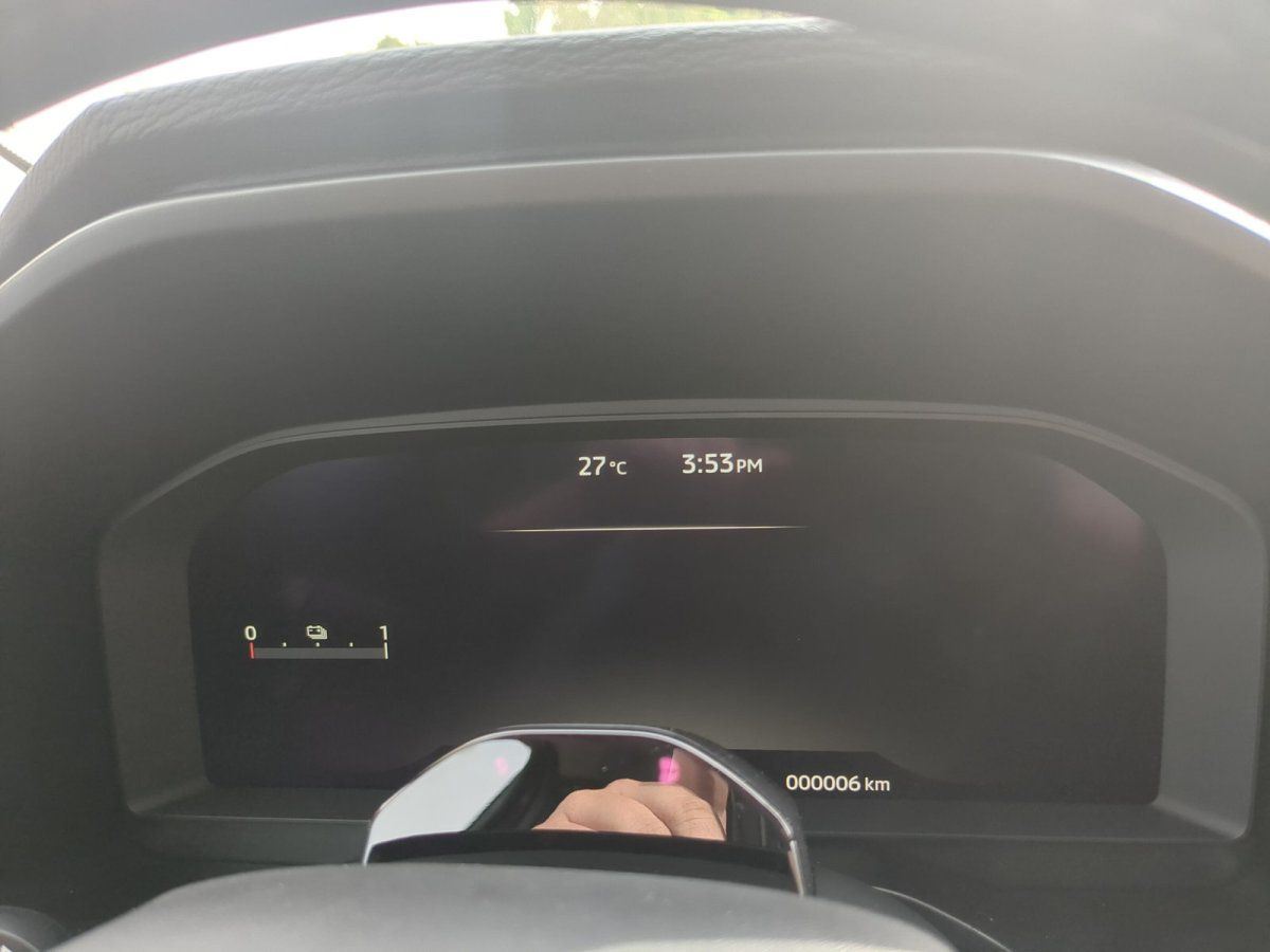 Digitales Cockpit-Display eines Neuwagens mit 6 km Kilometerstand im Autohaus-Showroom