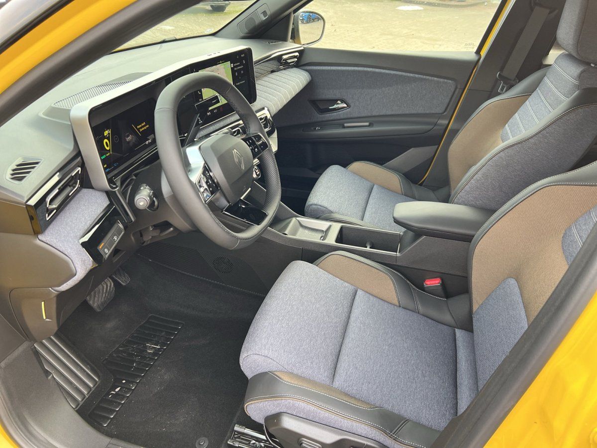 Renault Innenraum mit modernem Cockpit, großem Touchscreen und zweifarbigen Stoffsitzen in Grau-Braun