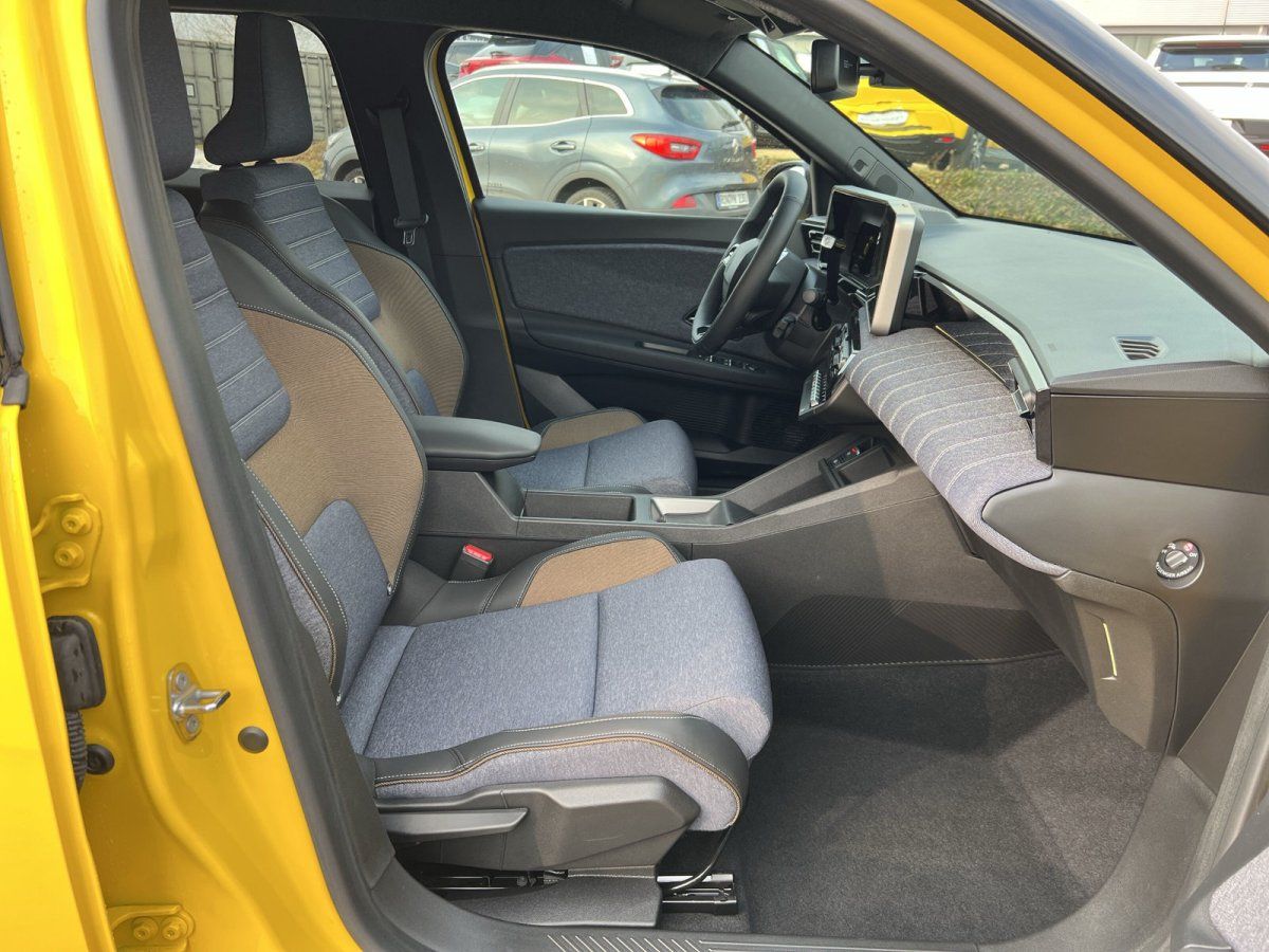 Renault Innenraum gelb – Fahrer- und Beifahrersitz mit blau-braunem Stoffbezug und großem Touchscreen