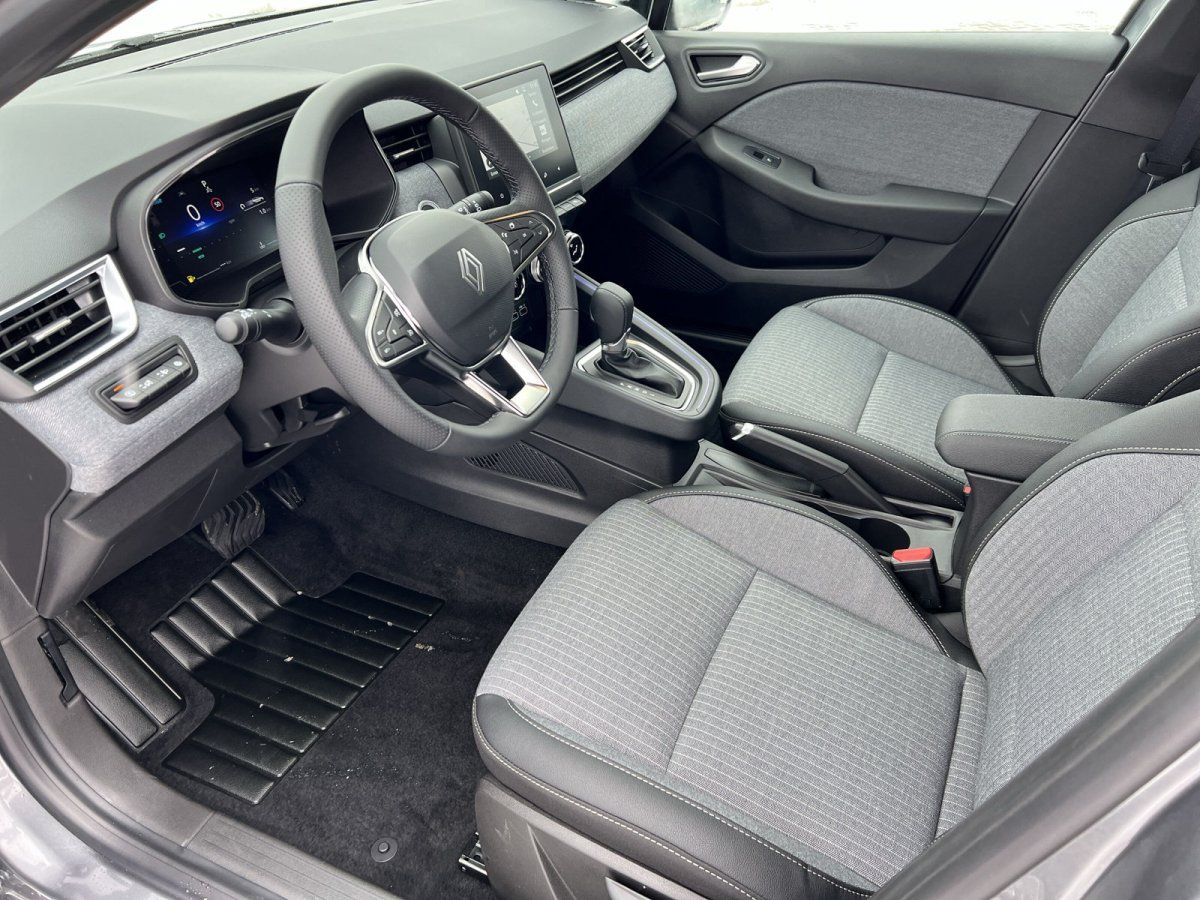 Renault Clio Innenraum mit digitalem Cockpit, Lenkrad und grauem Stoffsitzen in der Fahrzeughalle