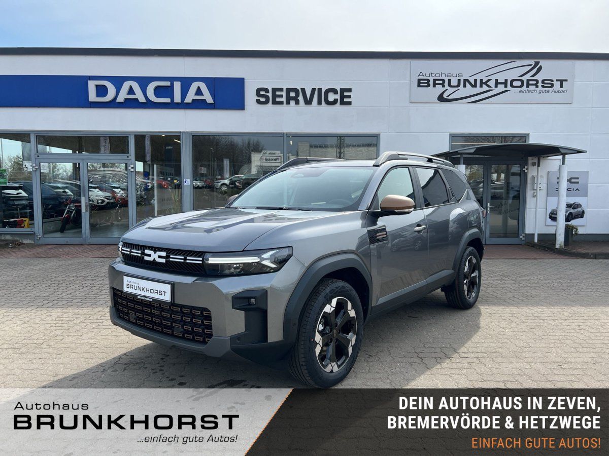 Grauer Dacia SUV im Autohaus Showroom - Frontansicht mit modernem Design und Dachträger