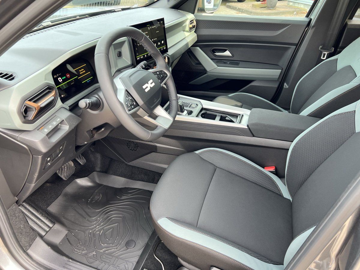 Moderner Dacia Innenraum mit schwarzem Cockpit, Touchscreen und sportlichen Sitzen