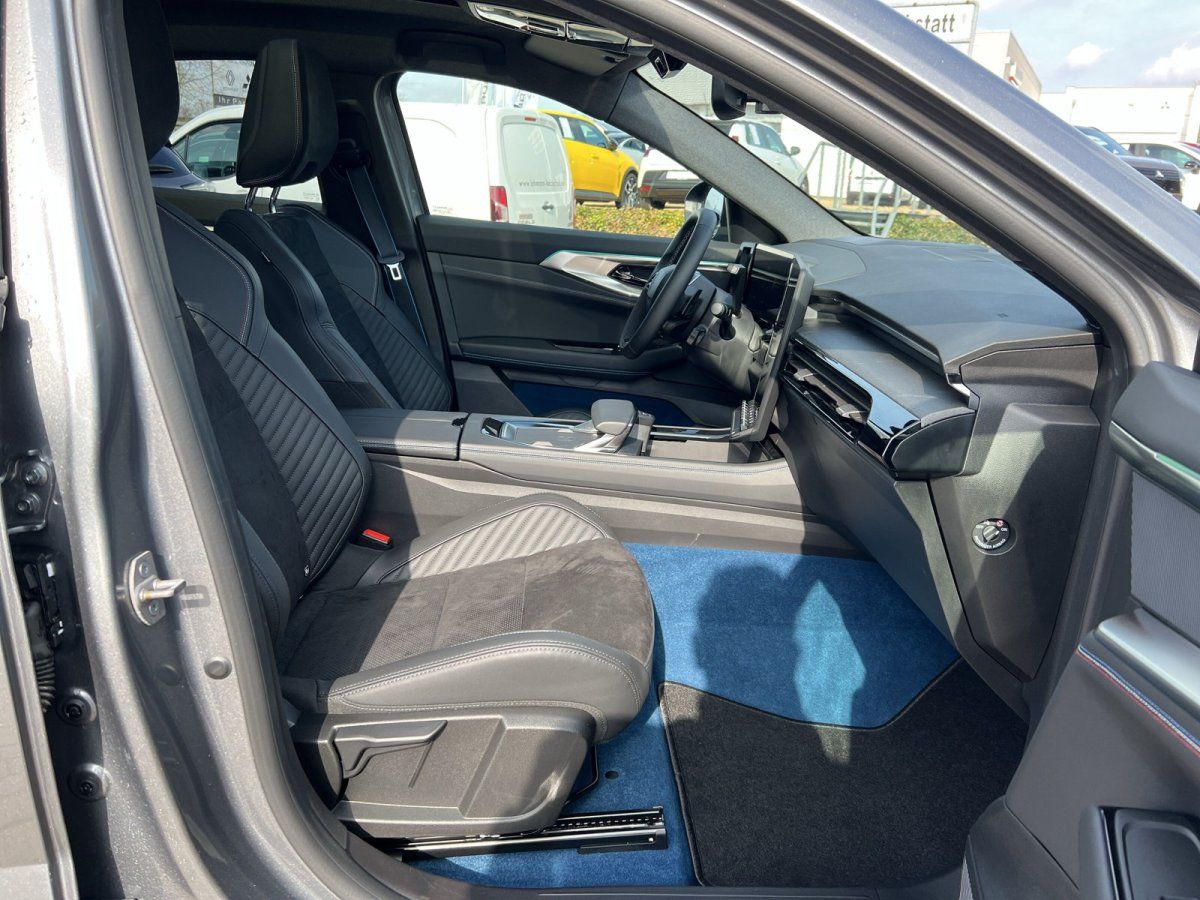 BMW Innenraum mit schwarzen Sportsitzen, blauem Fußmatten und modernem Cockpit mit Curved Display