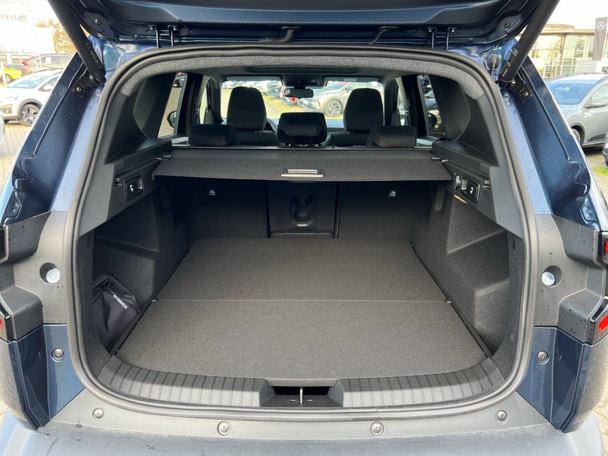 Kofferraum eines dunkelblauen SUV mit geöffneter Heckklappe und viel Laderaum