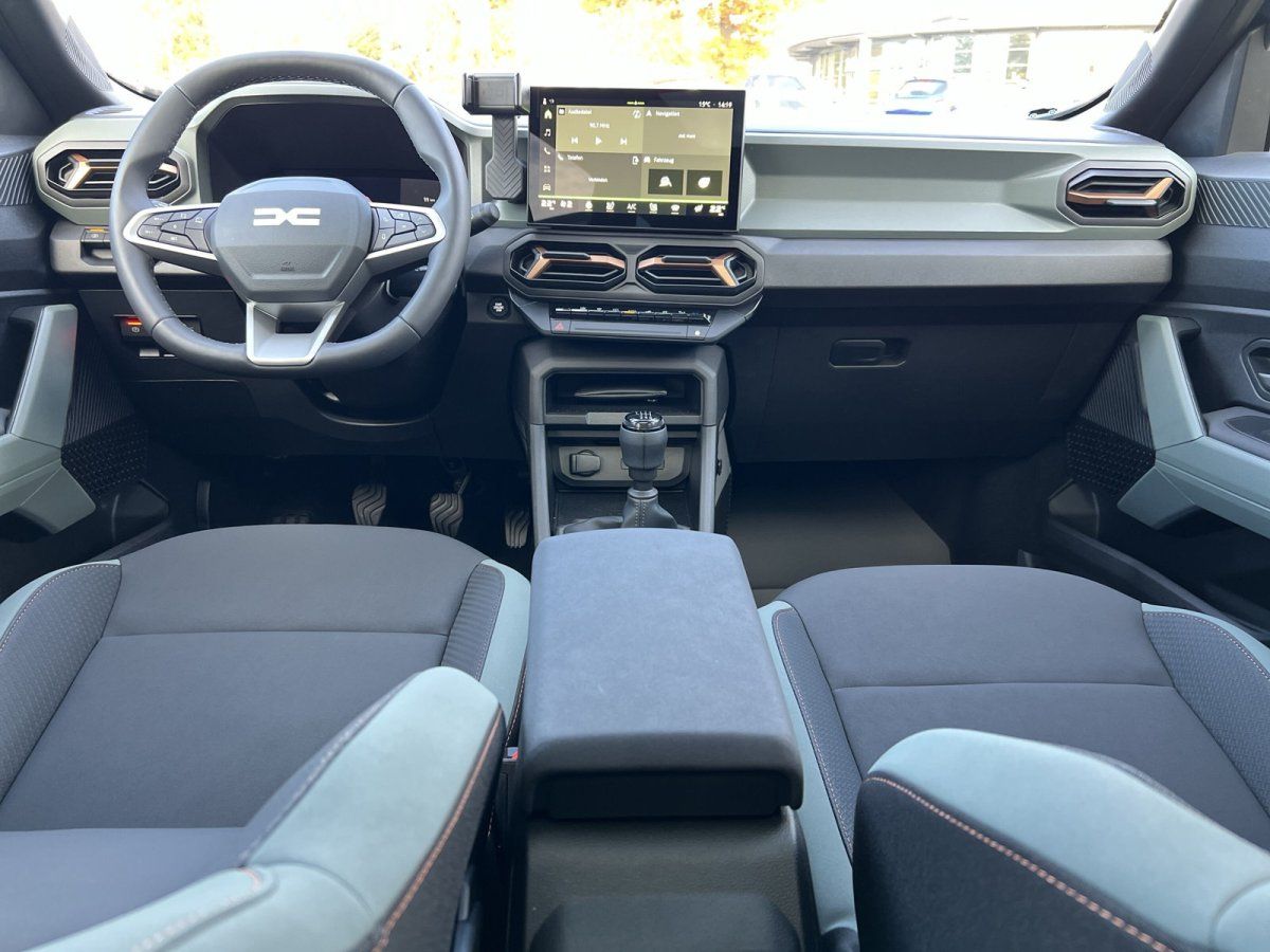 Dacia Innenraum mit Touchscreen, Lenkrad und grauen Stoffsitzen – modernes Cockpit in der Händlerausstellung