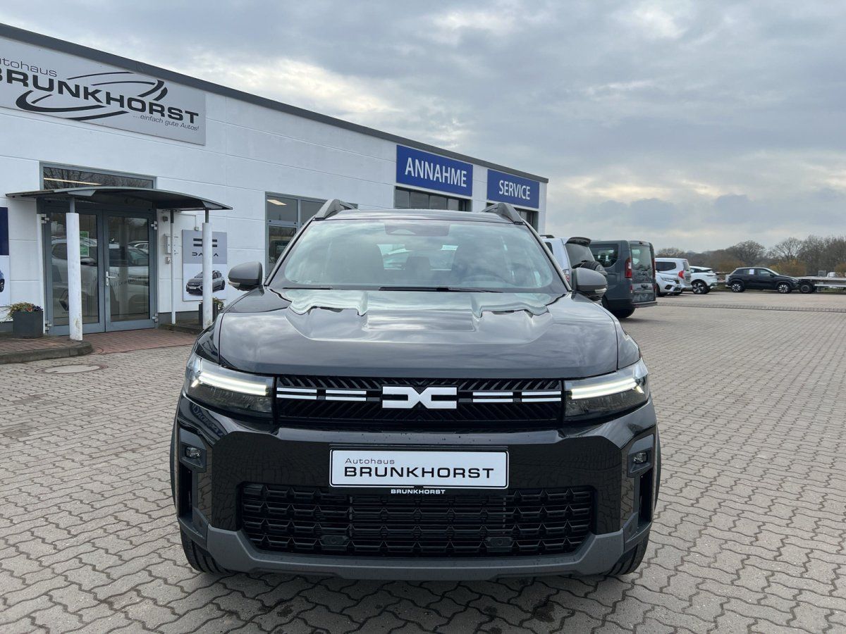 Schwarzer Dacia SUV Frontansicht im hellen Autohaus-Showroom mit großen Fenstern