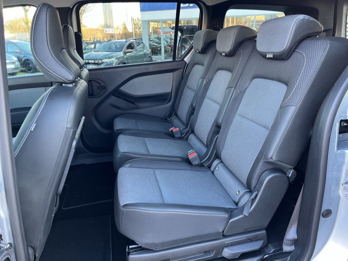 Fahrzeug-Innenraum mit drei Einzelsitzen in Schwarz-Grau, Sicherheitsgurte sichtbar, modernes Interieur