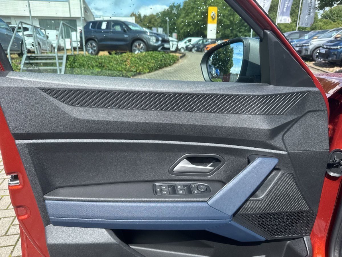 Rotes Fahrzeug Fahrertür Innenverkleidung mit Fensterheber und blauem Armlehneneinsatz im Autohaus