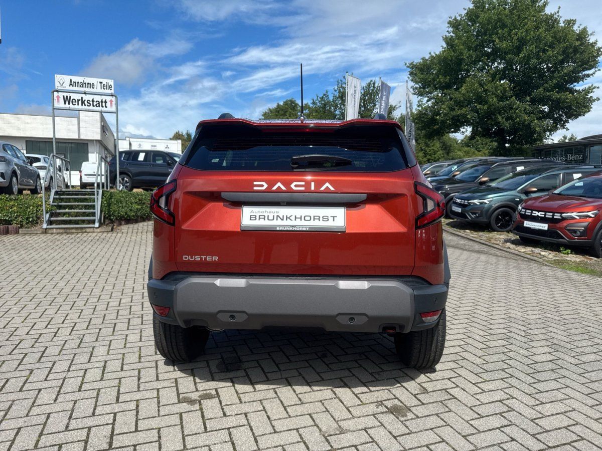 Dacia Duster SUV Heckansicht in Orange im Autohaus Brunkhorst Showroom